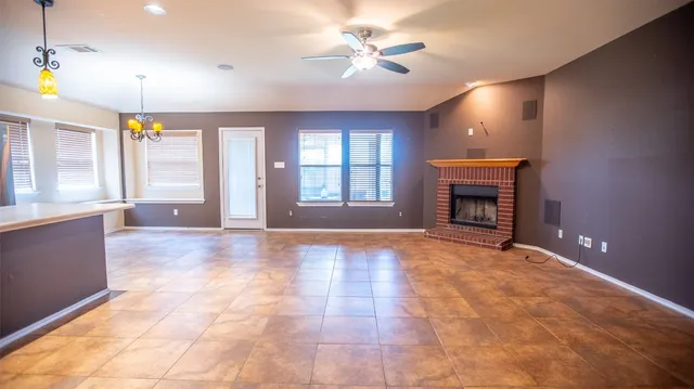 a view of an empty room with a fireplace and a window