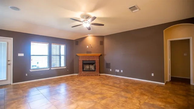 a view of empty room with window and fireplace
