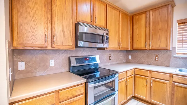 a kitchen with granite countertop cabinets stainless steel appliances and a window