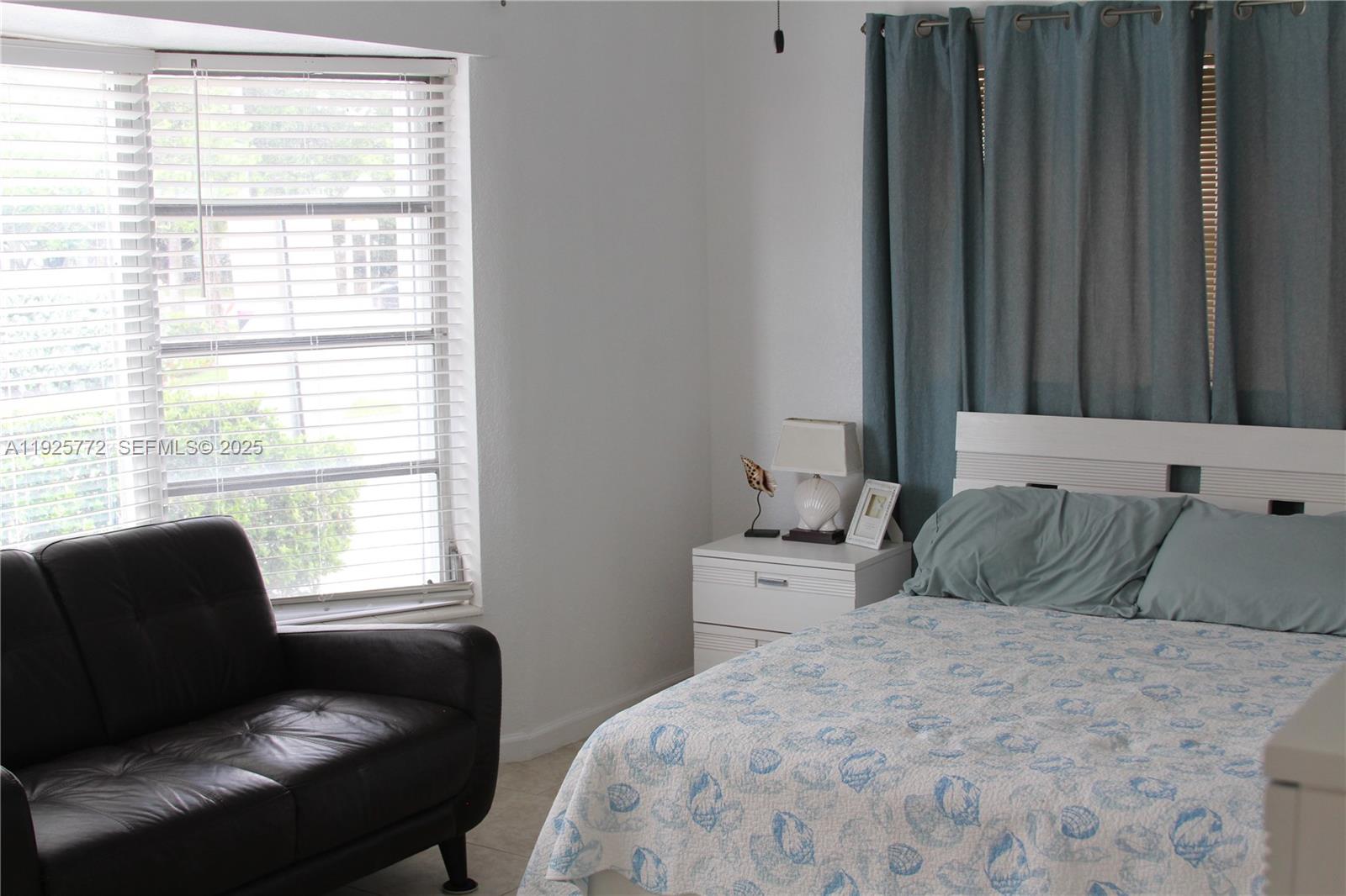 1300 North Ocean Boulevard, Unit 111 Pompano Beach, FL 33062 - Photo 11 of 26 a bedroom with a bed chair and window