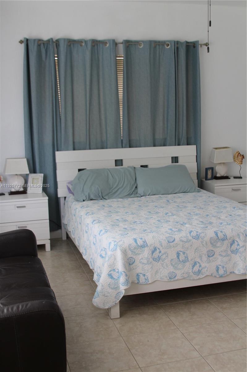 1300 North Ocean Boulevard, Unit 111 Pompano Beach, FL 33062 - Photo 12 of 26 a bedroom with a bed and a couch