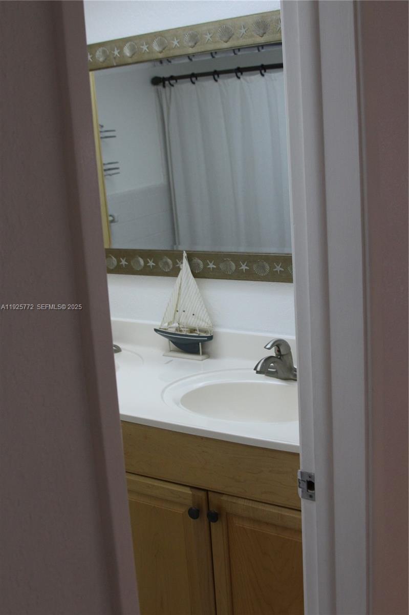 1300 North Ocean Boulevard, Unit 111 Pompano Beach, FL 33062 - Photo 14 of 26 a bathroom with a sink and a mirror