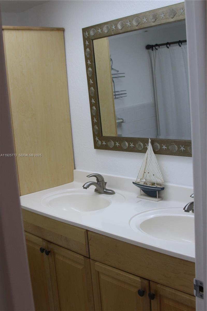 1300 North Ocean Boulevard, Unit 111 Pompano Beach, FL 33062 - Photo 16 of 26 a bathroom with a sink and a mirror