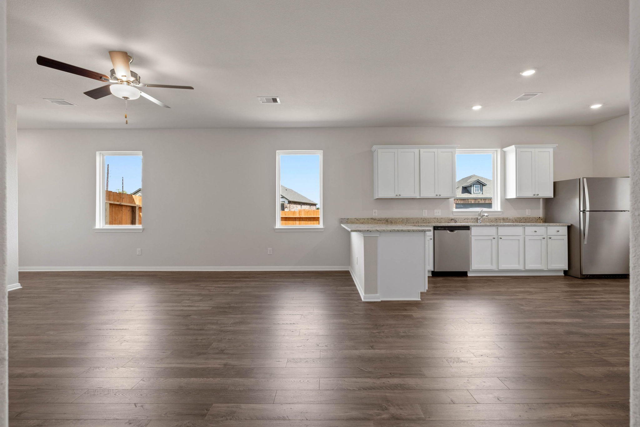 7506 Tipton Meadow Way Richmond, TX 77469 - Photo 4 of 21 a kitchen with stainless steel appliances granite countertop a stove top oven a sink with white cabinets and wooden floor