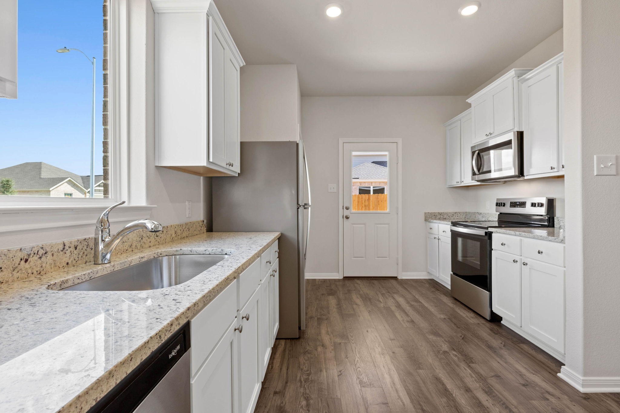 7506 Tipton Meadow Way Richmond, TX 77469 - Photo 8 of 21 a kitchen with granite countertop a sink stove and cabinets