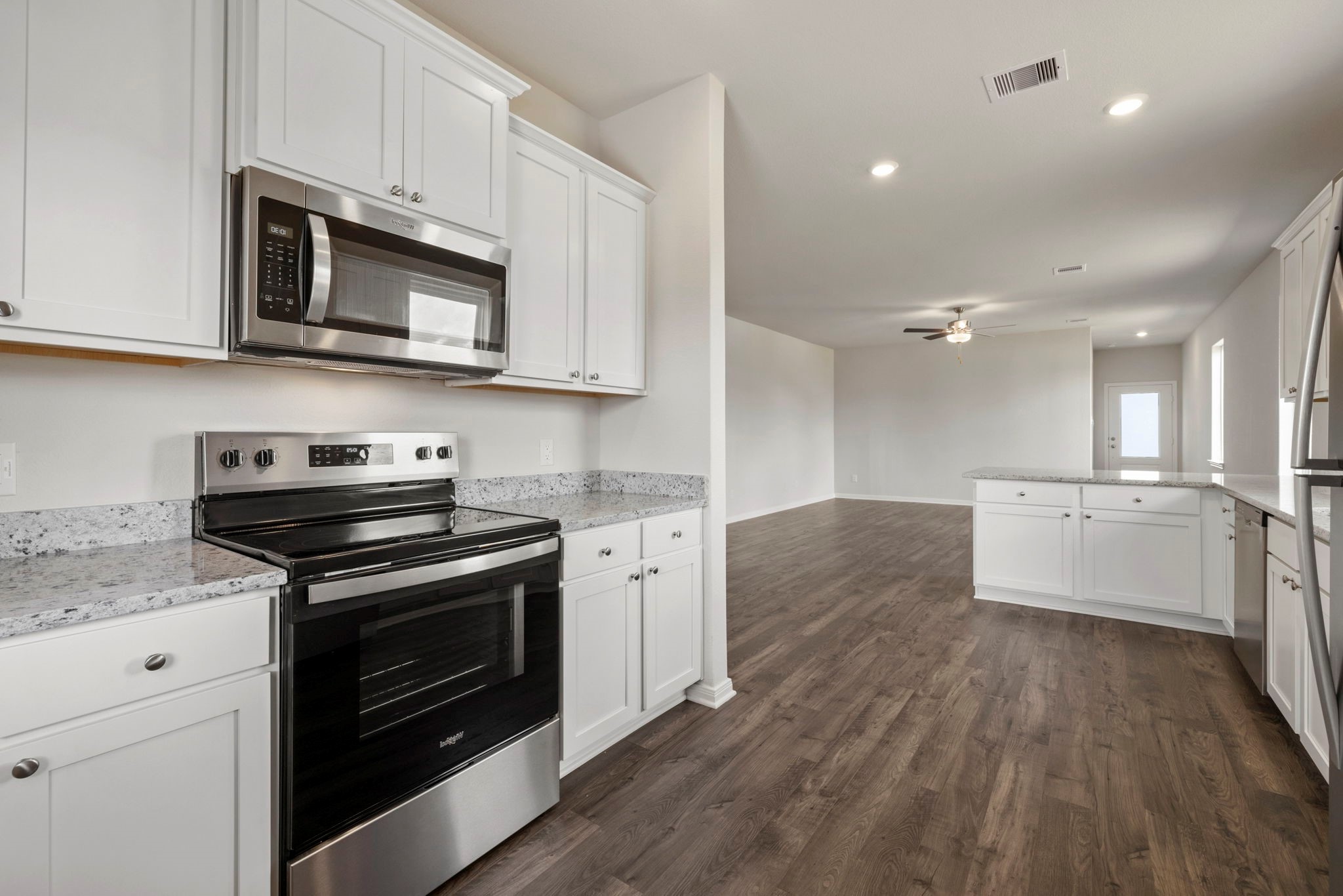 7506 Tipton Meadow Way Richmond, TX 77469 - Photo 10 of 21 a kitchen with stainless steel appliances white cabinets a stove a sink and a microwave