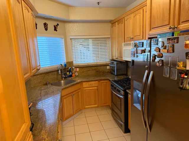a kitchen with stainless steel appliances granite countertop a sink stove and refrigerator