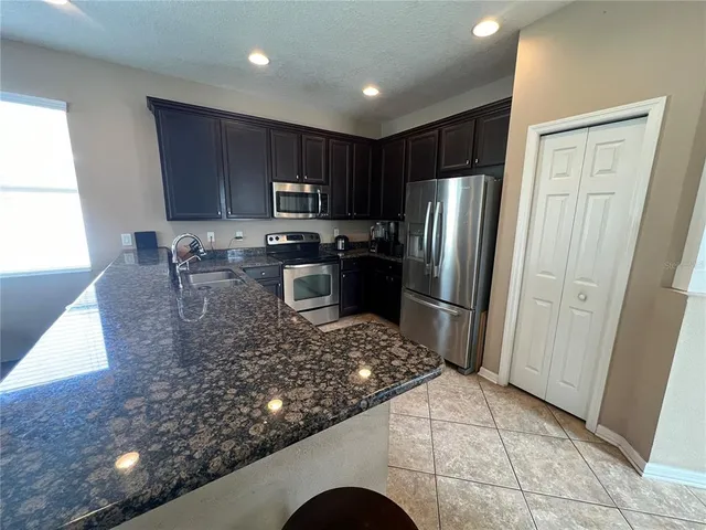 a living room with lots of furniture and view of kitchen