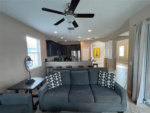 a living room with furniture a flat screen tv and a large window