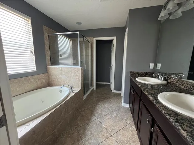 en empty room with windows and ceiling fan