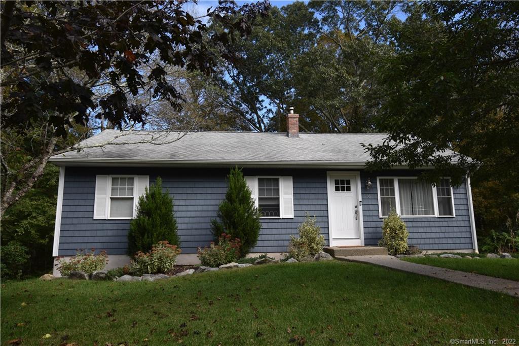 a front view of a house with a garden and yard