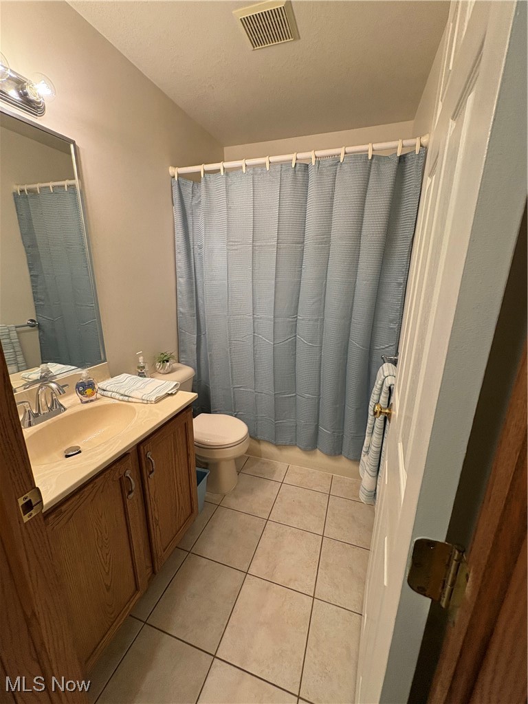 2003 East County Line Road Mineral Ridge, OH 44440 - Photo 27 of 33 Bathroom with vanity, light tile patterned floors, curtained shower, and a textured ceiling