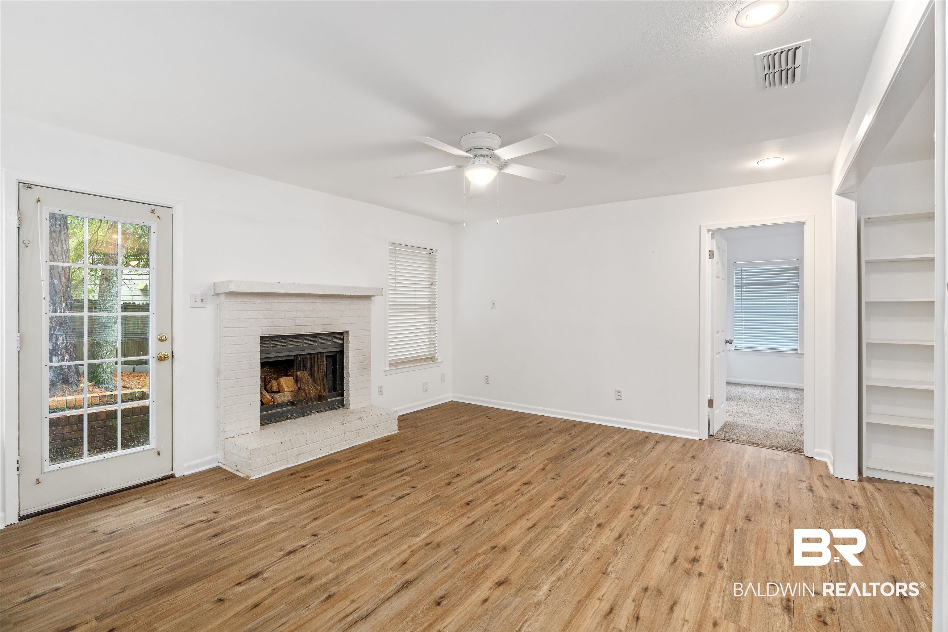 159 Montclair Loop Daphne, AL 36526 - Photo 5 of 18 Unfurnished living room with light wood-style flooring, ceiling fan, and a fireplace