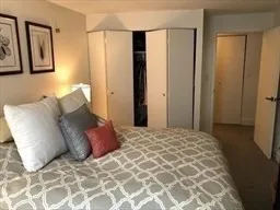 a large bed sitting in a bedroom and a mirror