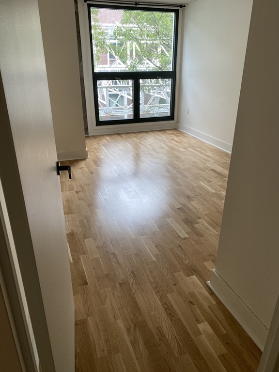 42 8th Street, Unit 5313 Boston, MA 02129 - Photo 12 of 16 an empty room with wooden floor and windows