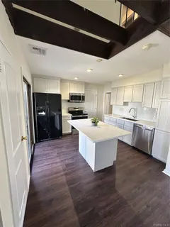 a large kitchen with a large counter top appliances and cabinets