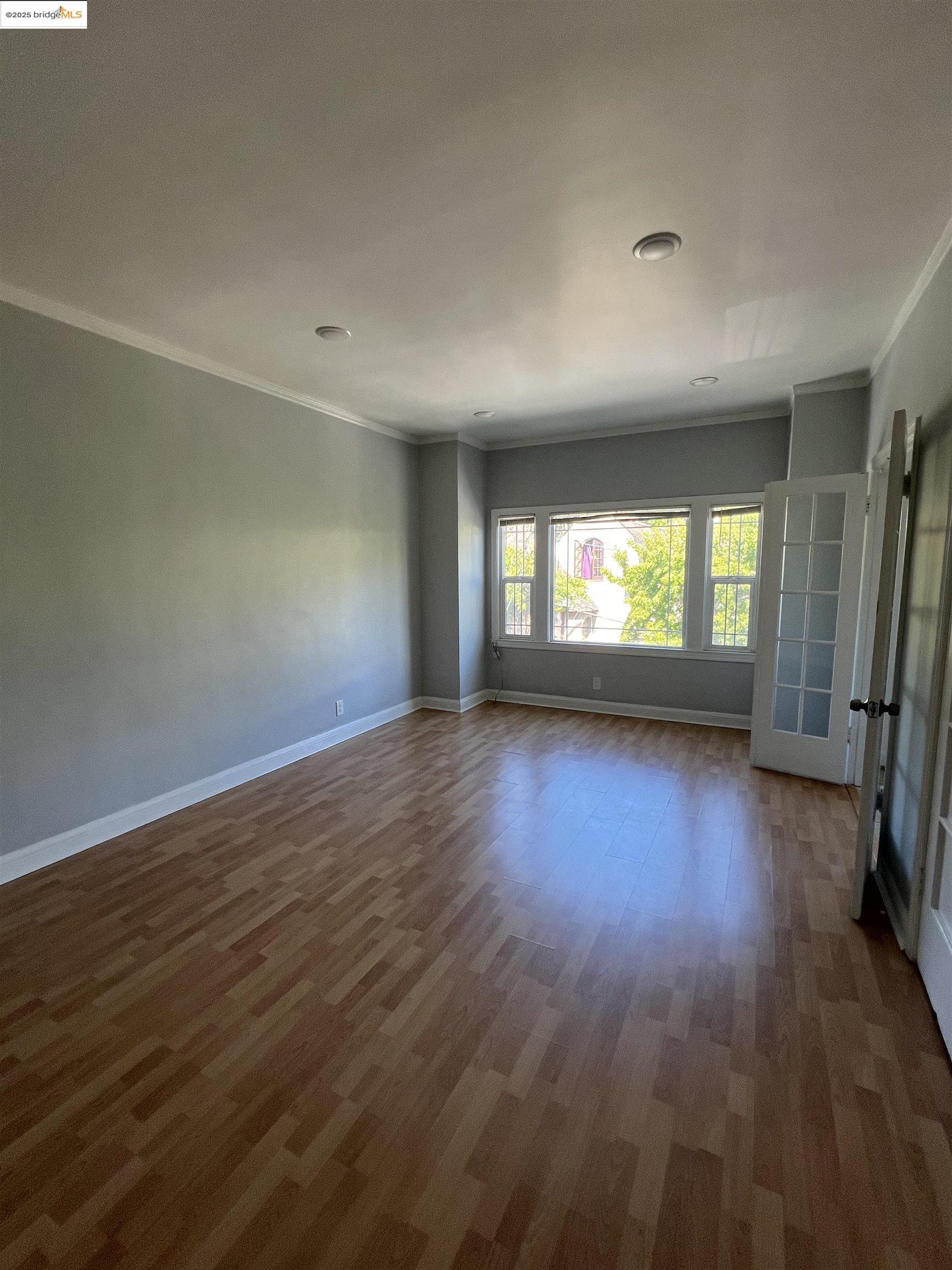 1846 Spruce Street, Unit 31 Berkeley, CA 94709 - Photo 2 of 8 an empty room with wooden floor and a window