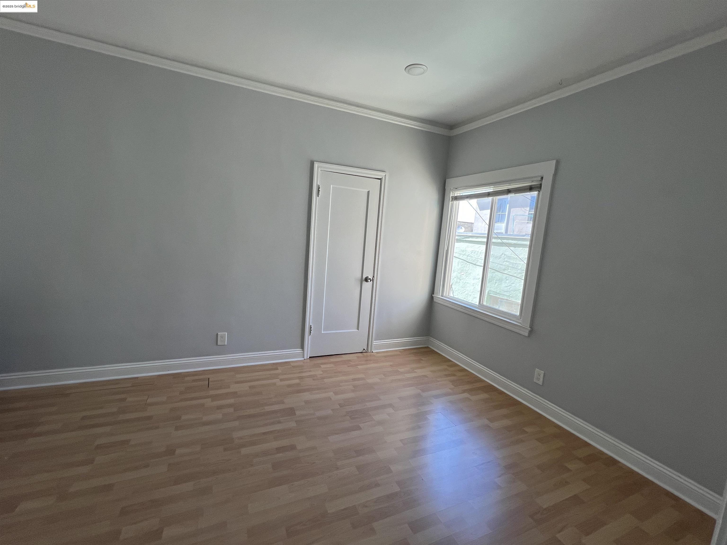 1846 Spruce Street, Unit 31 Berkeley, CA 94709 - Photo 3 of 8 a view of an empty room with wooden floor and a window