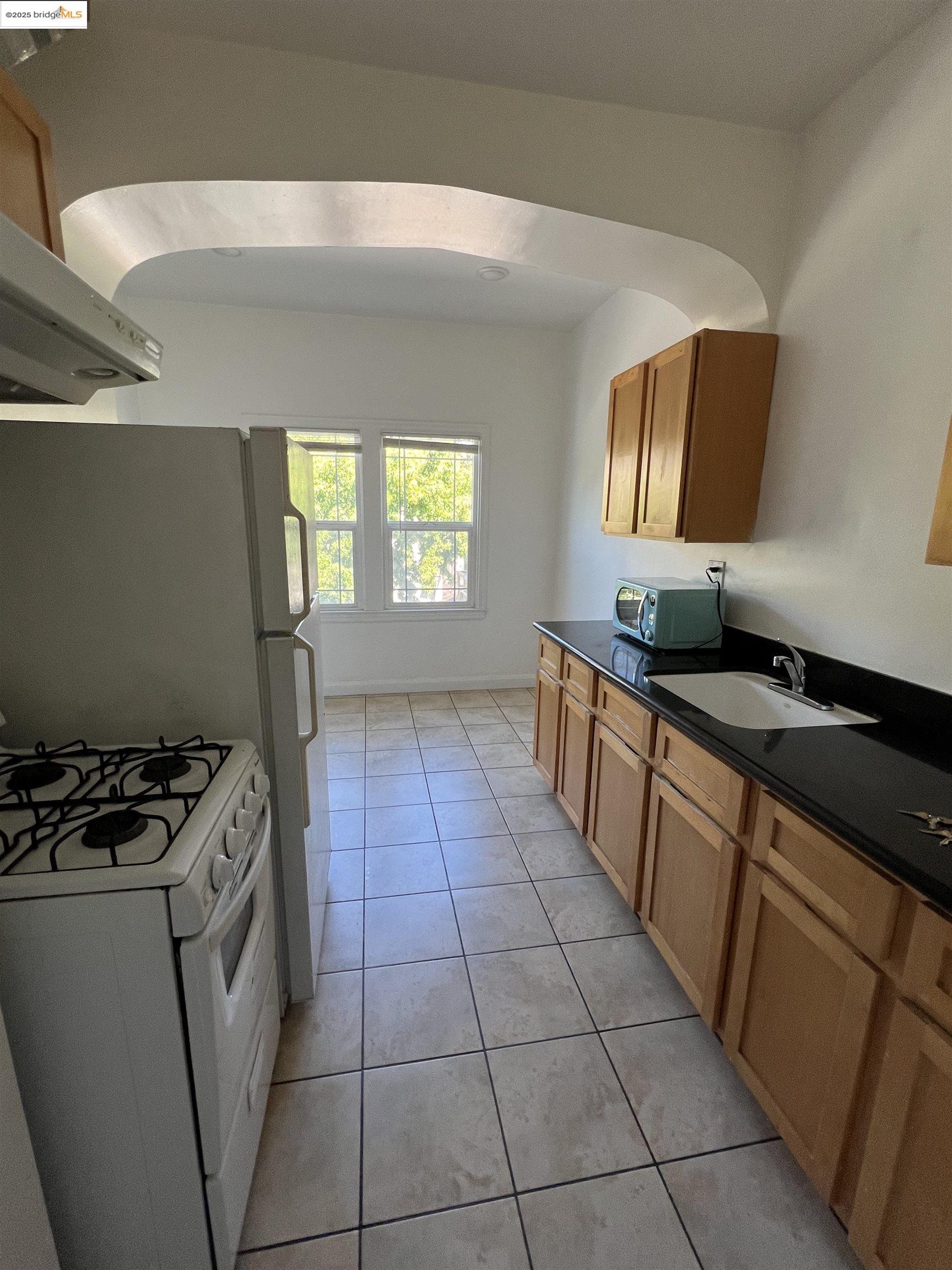 1846 Spruce Street, Unit 31 Berkeley, CA 94709 - Photo 4 of 8 a kitchen with a sink a stove and a microwave