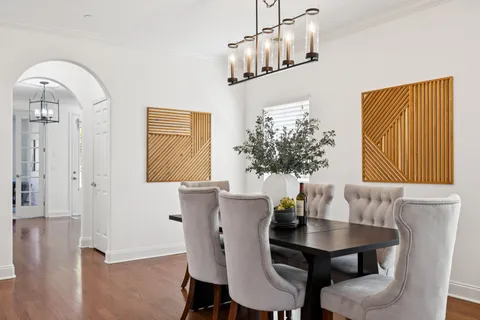 a kitchen with stainless steel appliances granite countertop a refrigerator a sink a stove a dining table and chairs