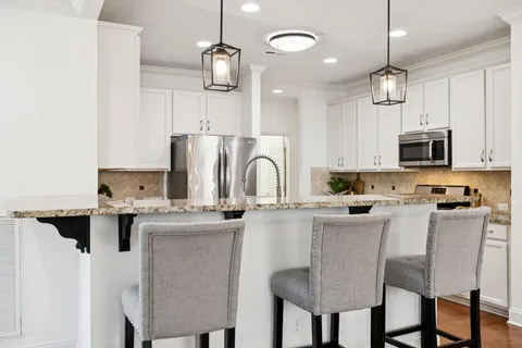 a kitchen with stainless steel appliances granite countertop a stove top oven a sink and a microwave