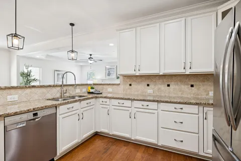 a kitchen with a sink and a wooden floor