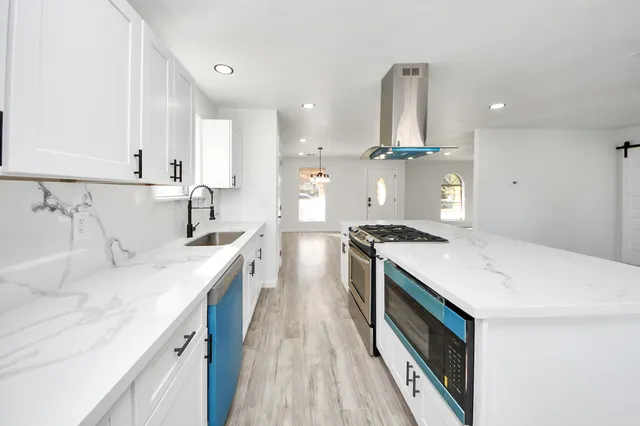 a large kitchen with stainless steel appliances lots of counter space and a sink