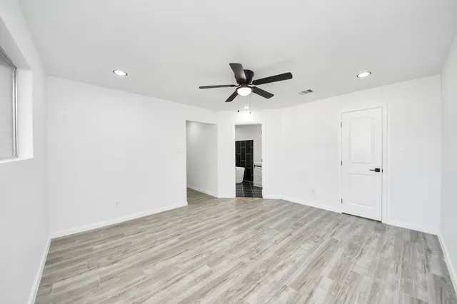 a view of a livingroom with a ceiling fan & wooden floor