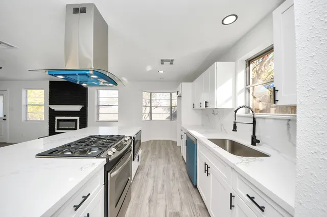 a kitchen with stainless steel appliances a sink stove and cabinets