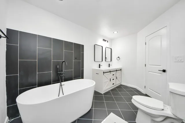 a bathroom with a toilet a sink a mirror a bathtub and shower