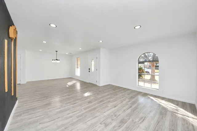 an empty room with windows and wooden floor