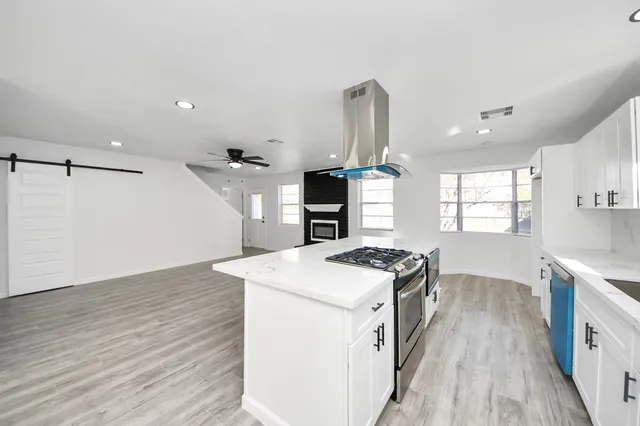 a kitchen with a stove and a wooden floors