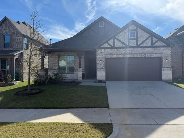 a front view of a house with a garden and yard