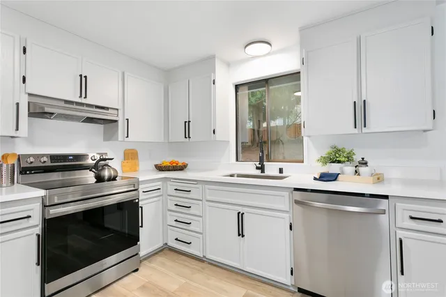 a kitchen with white cabinets and white appliances