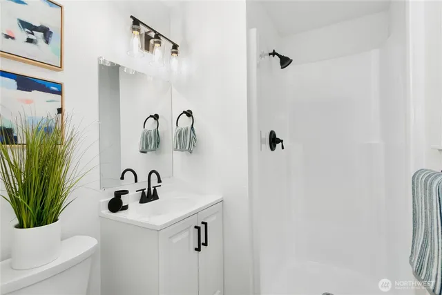 a bathroom with a sink a mirror and a potted plant