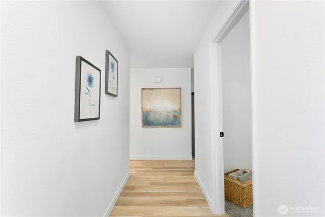 a view of a hallway with wooden floor and entryway