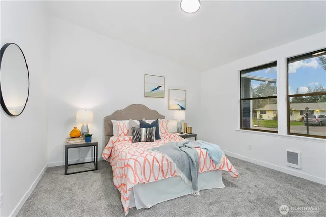 a bedroom with a bed a mirror and night stand