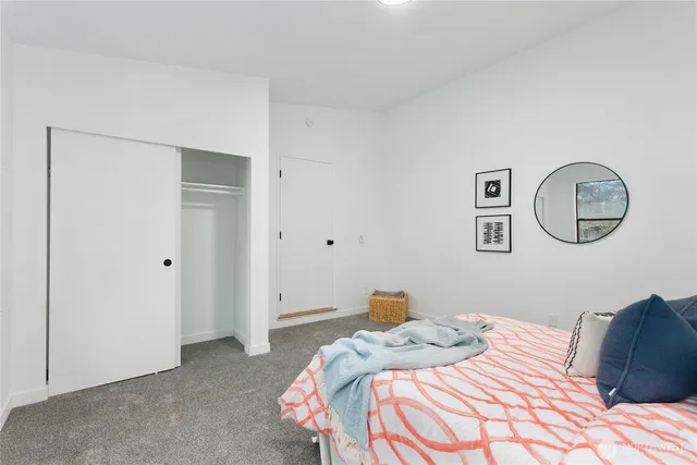 a bedroom with a bed and a lamp on the dresser