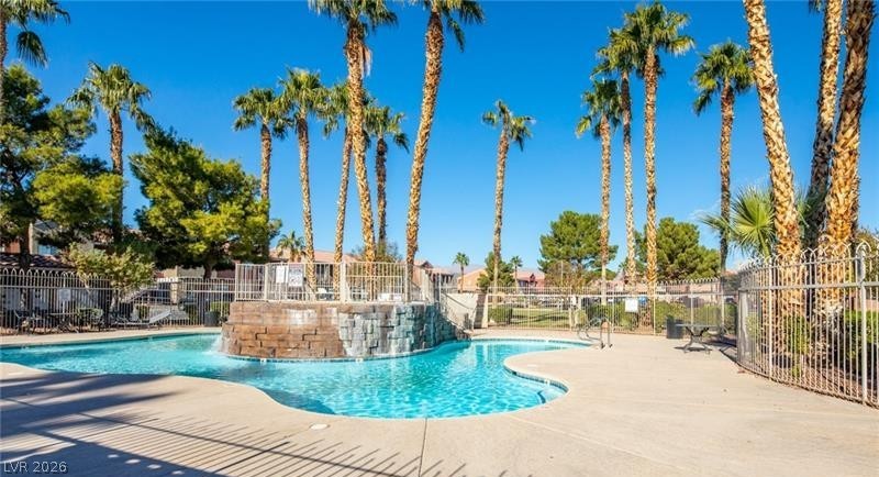 An inviting pool area with a waterfall feature, perfect for relaxation and recreation.