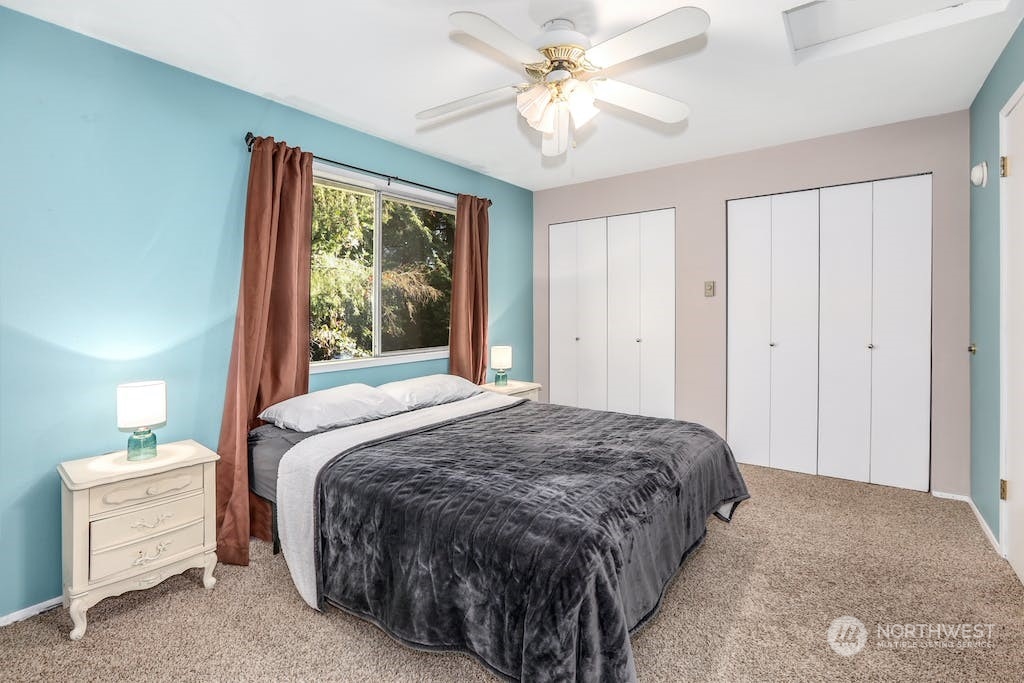 18910 Bothell Everett Highway, Unit D3 Bothell, WA 98012 - Photo 19 of 29 a spacious bedroom with a bed and a chandelier