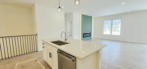a kitchen that has a sink a oven and wooden floor