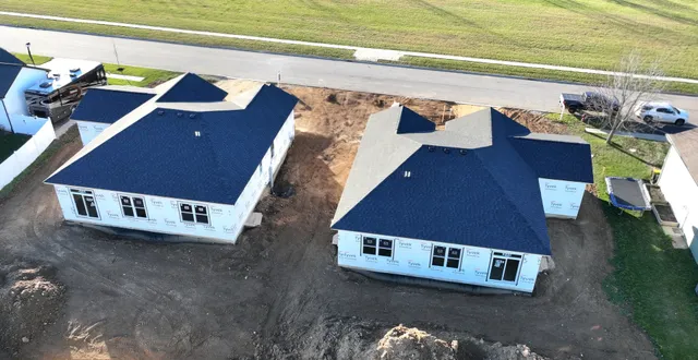 an aerial view of a house with a yard and lake view