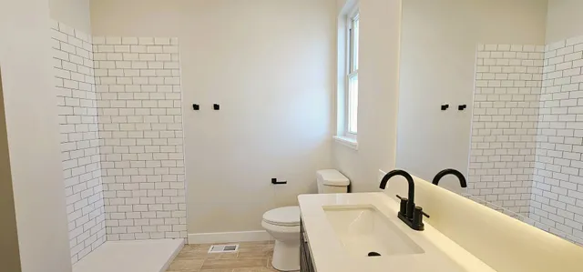 a bathroom with a sink a toilet and shower