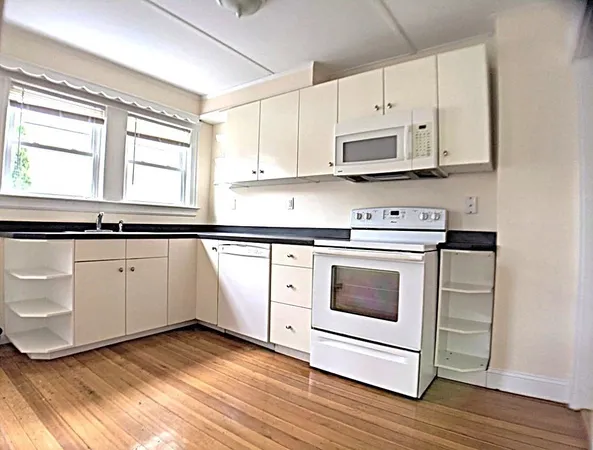 a kitchen with granite countertop white cabinets and white appliances