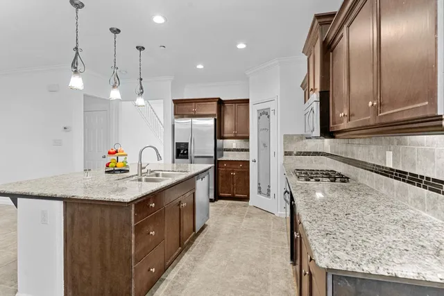 a kitchen with stainless steel appliances granite countertop a sink stove and refrigerator