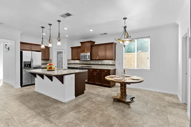 a kitchen with kitchen island a sink stove and refrigerator