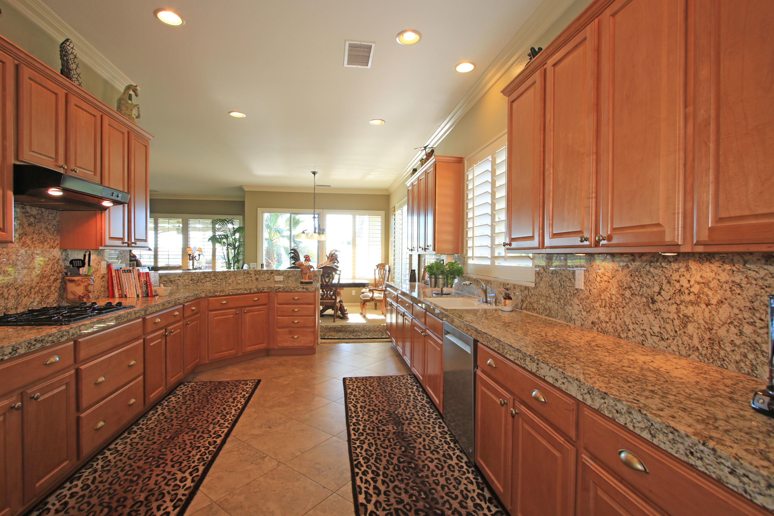 44530 Knightswood Road Indio, CA 92201 - Photo 11 of 38 a large kitchen with stainless steel appliances granite countertop a lot of counter space and a sink