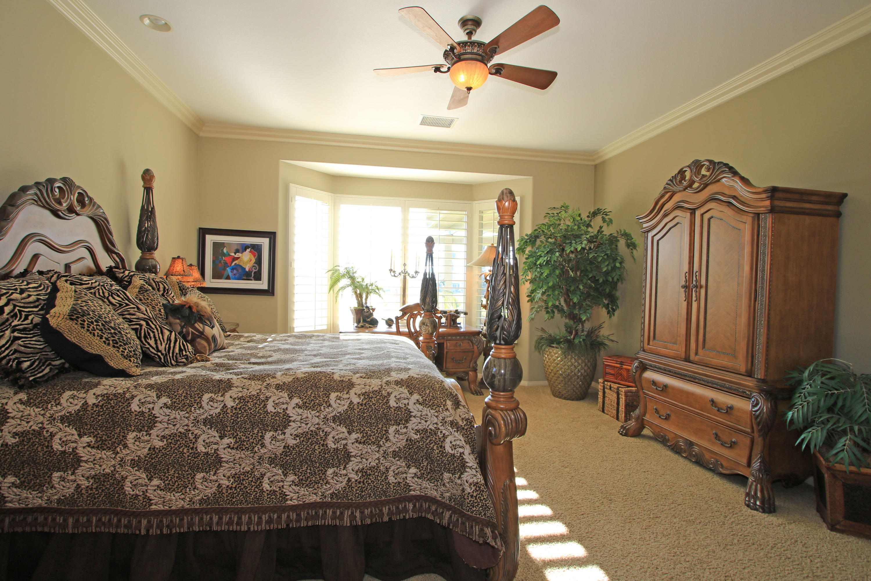 44530 Knightswood Road Indio, CA 92201 - Photo 17 of 38 a bedroom with a bed a dresser and potted plants