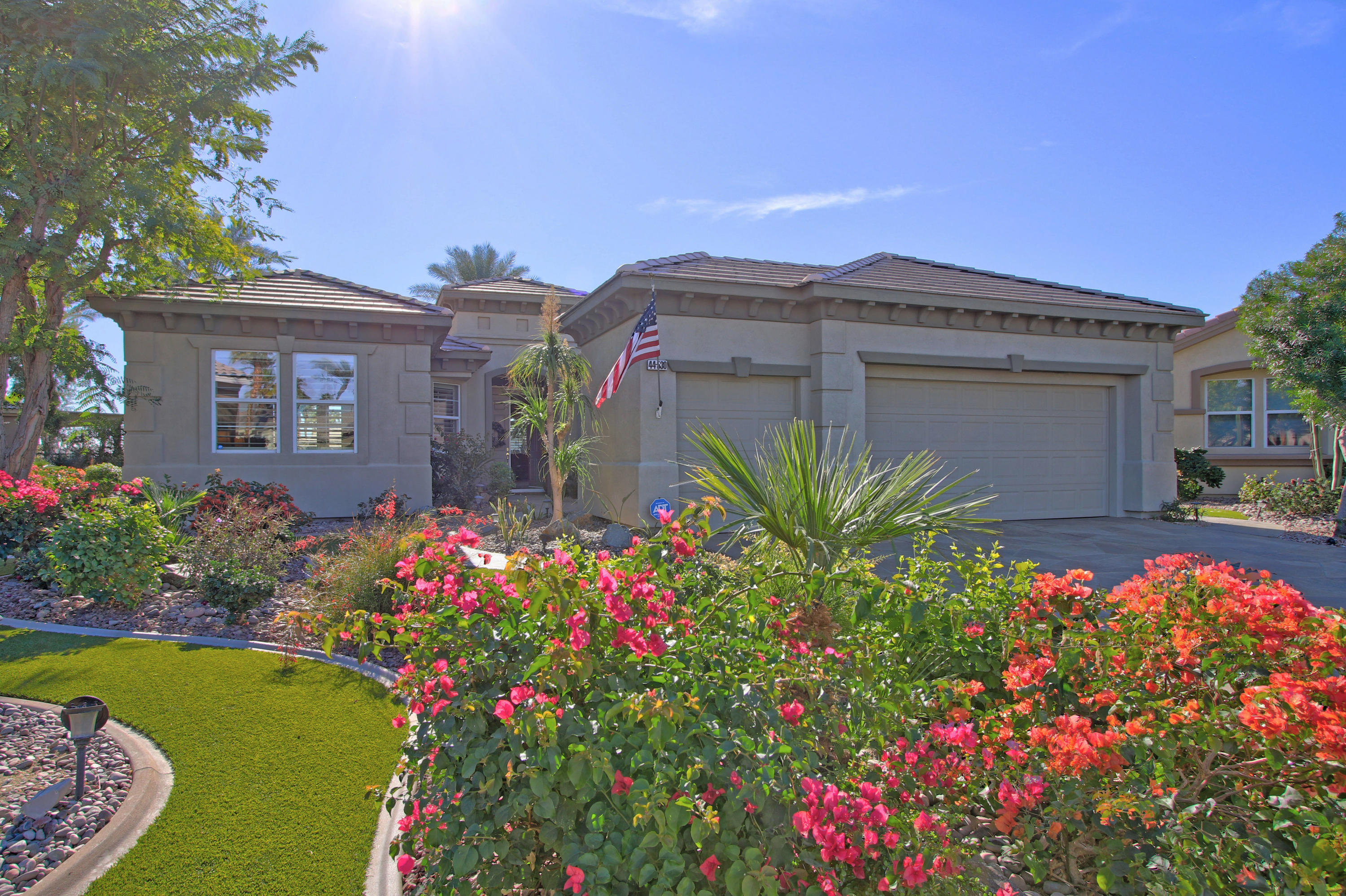 44530 Knightswood Road Indio, CA 92201 - Photo 3 of 38 a front view of house and yard with beautiful flowers