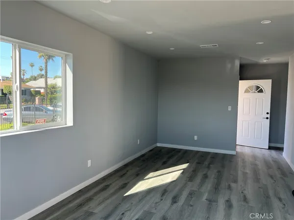 a view of room with window and wooden floor